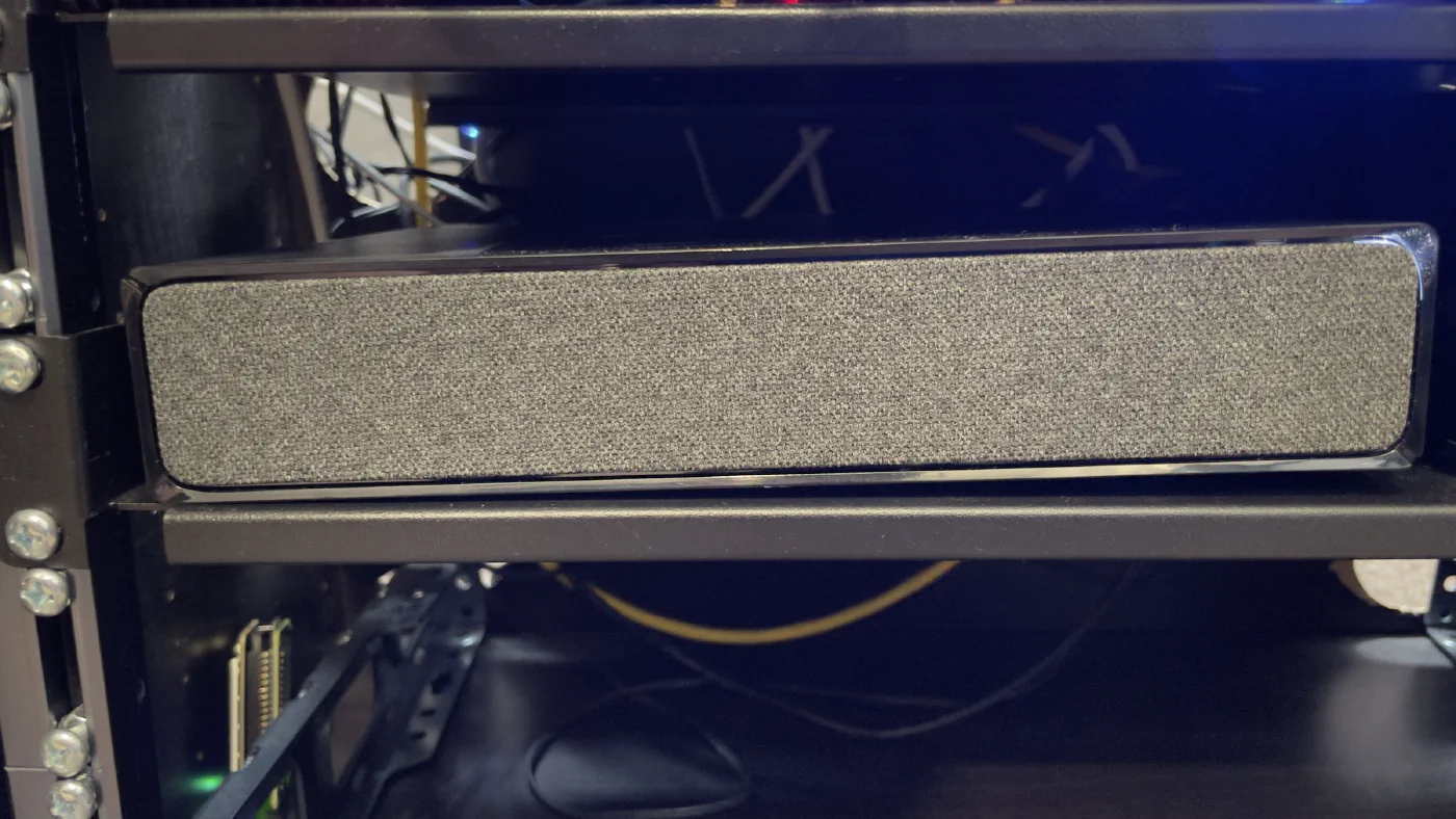 The Virgin Media Hub 5x sitting on a shelf inside a dark network rack cabinet